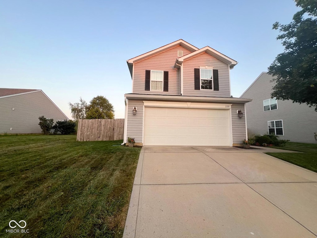 view of property featuring a front yard and a garage