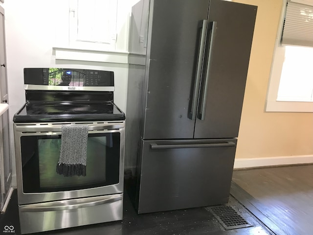 kitchen featuring white cabinetry, appliances with stainless steel finishes, and dark hardwood / wood-style flooring