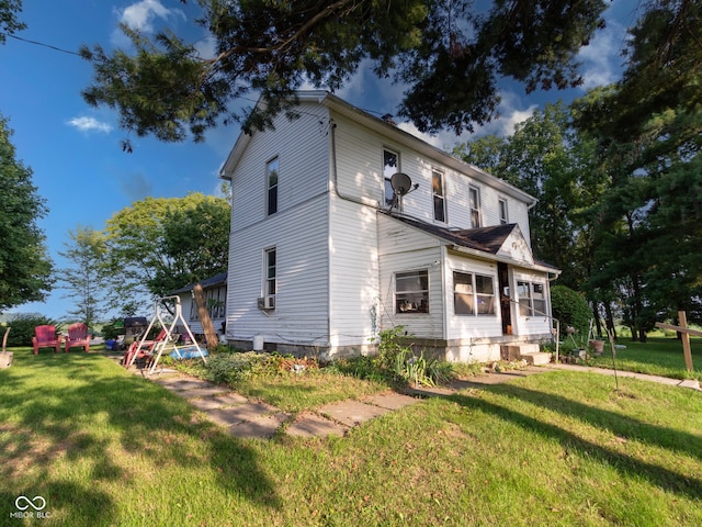 view of side of home featuring cooling unit and a yard