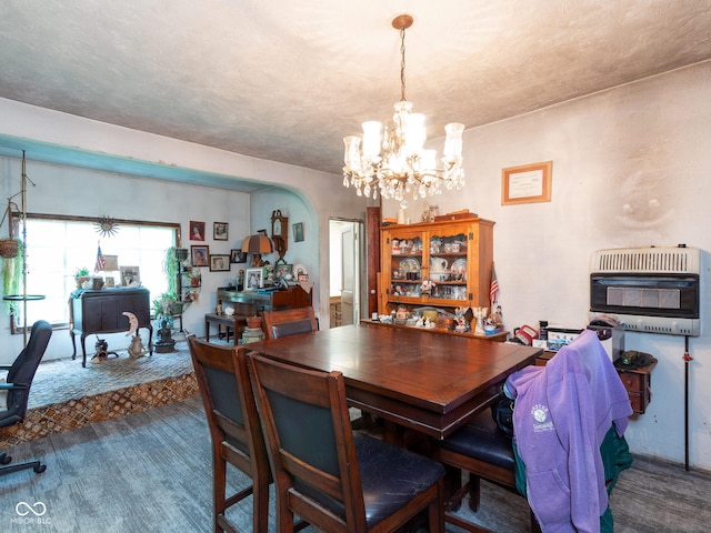 dining area featuring an inviting chandelier, heating unit, a textured ceiling, and carpet flooring