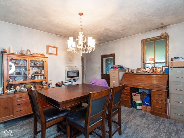 dining area with a notable chandelier, heating unit, and a textured ceiling