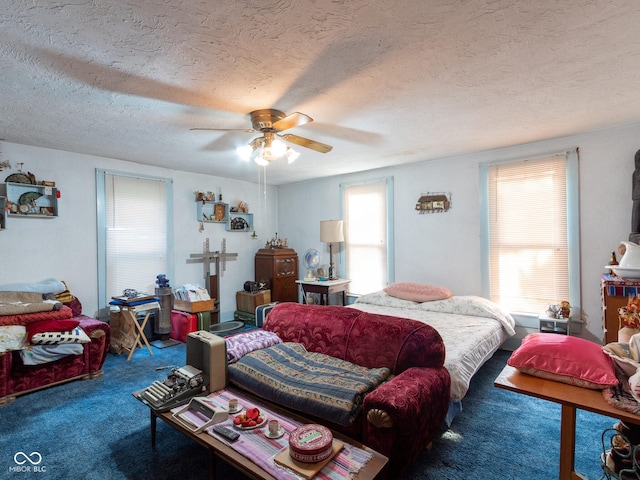 carpeted bedroom with ceiling fan and a textured ceiling