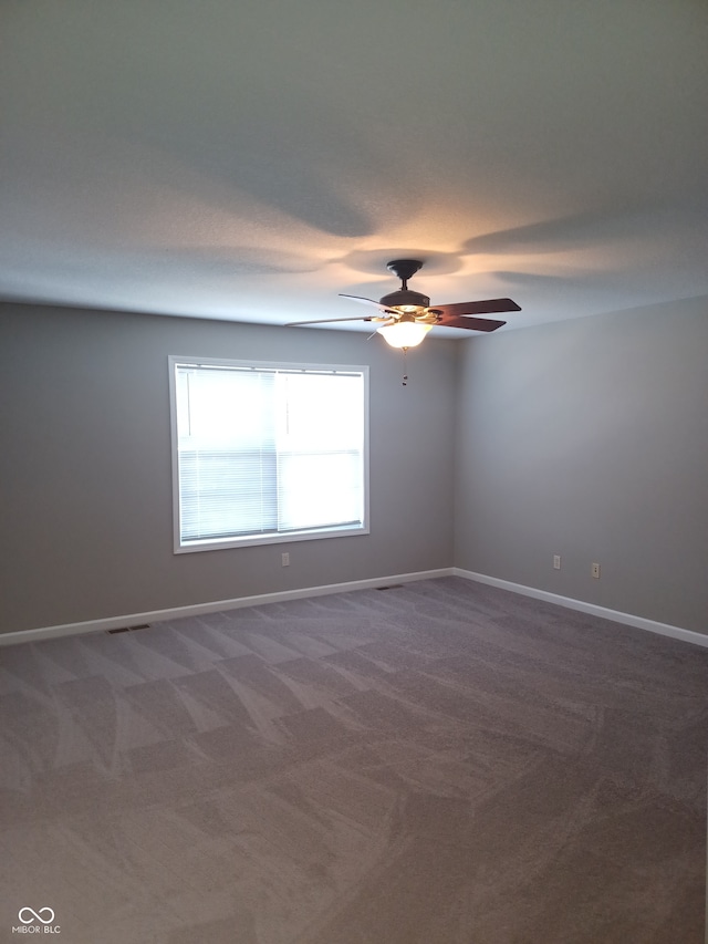 carpeted spare room with ceiling fan