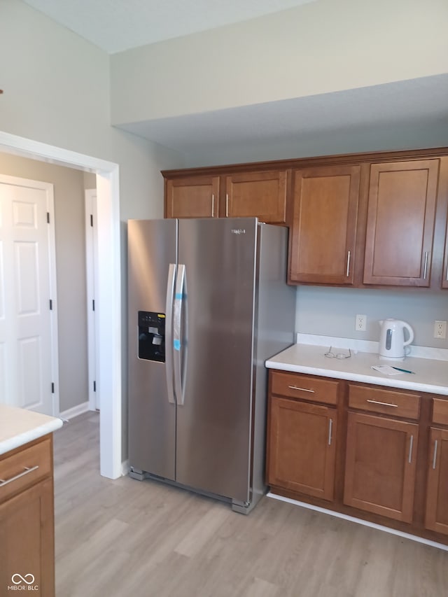 kitchen featuring stainless steel refrigerator with ice dispenser and light hardwood / wood-style flooring