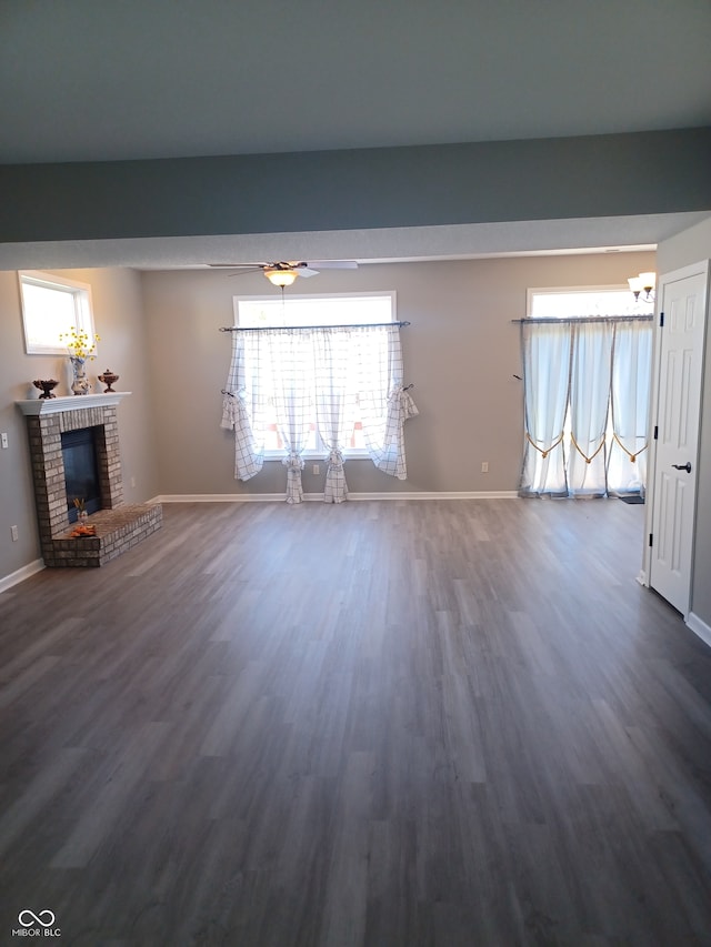 unfurnished living room featuring a brick fireplace and dark hardwood / wood-style floors