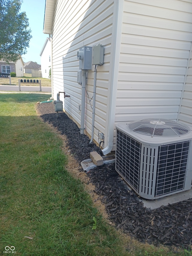 view of property exterior featuring central AC unit and a lawn