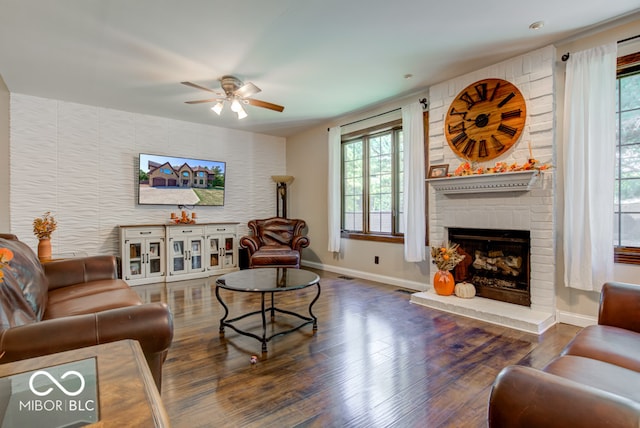 living room featuring ceiling fan, a fireplace, and dark hardwood / wood-style flooring