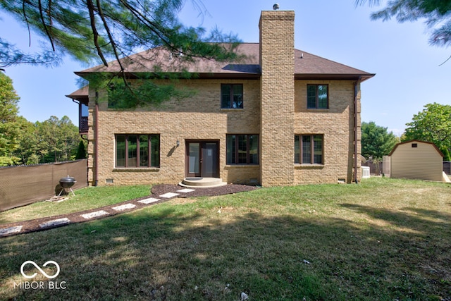 back of house featuring a yard and a storage shed