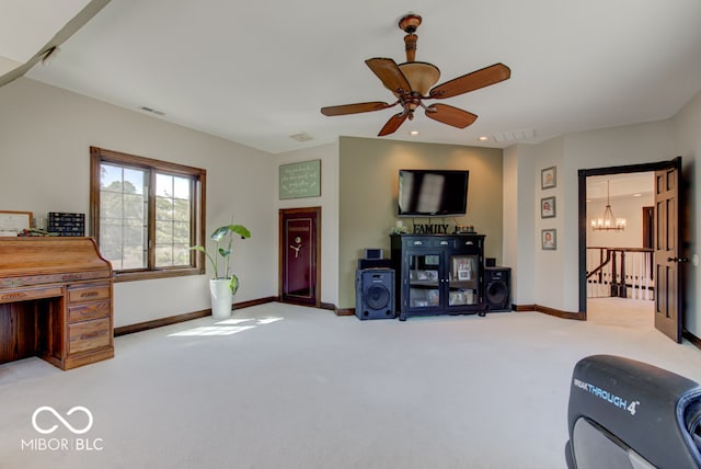 carpeted living room featuring ceiling fan with notable chandelier