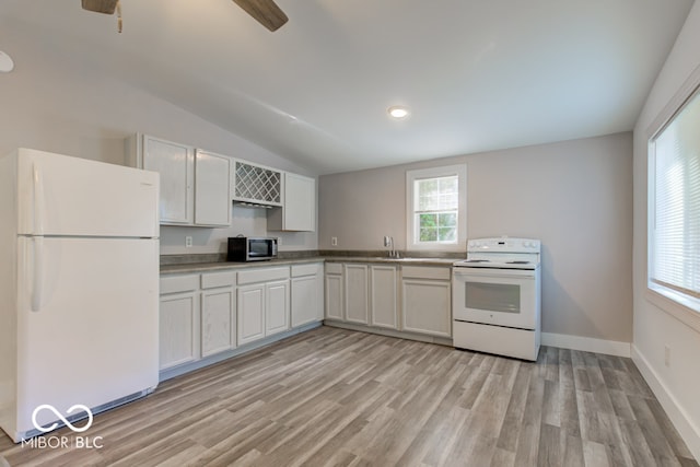 kitchen with white appliances, vaulted ceiling, light hardwood / wood-style flooring, and white cabinets