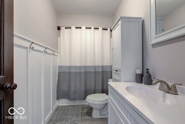 bathroom featuring vanity, wood-type flooring, toilet, and walk in shower