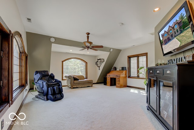 living area featuring light carpet and ceiling fan