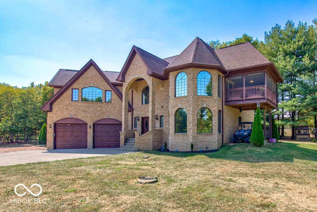 french provincial home with a front yard, a garage, and a balcony