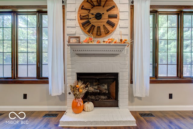 interior details with hardwood / wood-style floors and a brick fireplace