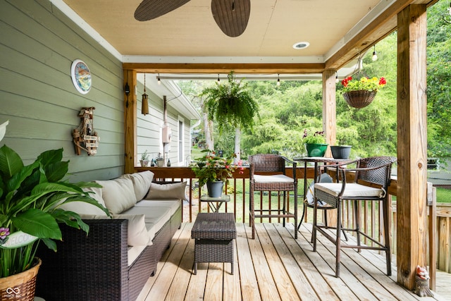 wooden terrace with an outdoor living space and ceiling fan