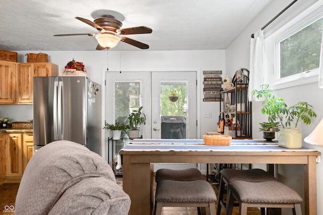 kitchen featuring ceiling fan, a textured ceiling, stainless steel fridge, and french doors