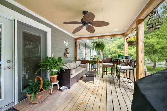 wooden terrace with ceiling fan, grilling area, and an outdoor hangout area