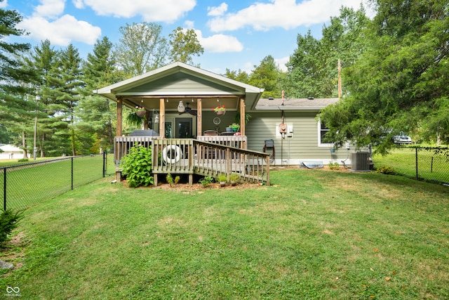 rear view of property with ceiling fan, a deck, a yard, and central AC