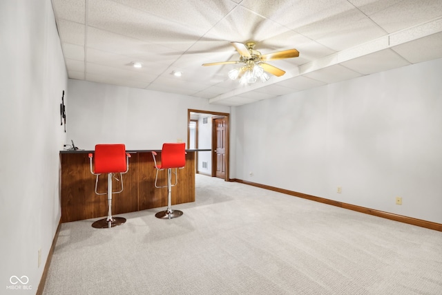 bar with a paneled ceiling, ceiling fan, and carpet floors