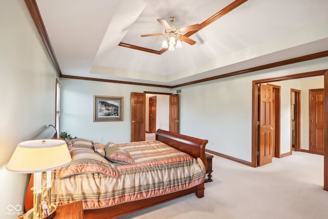 carpeted bedroom with a raised ceiling, ceiling fan, and crown molding