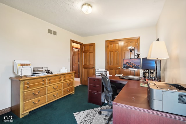 carpeted office with a textured ceiling