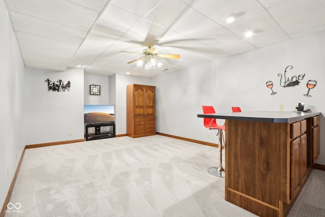 bar with light carpet, a drop ceiling, and ceiling fan