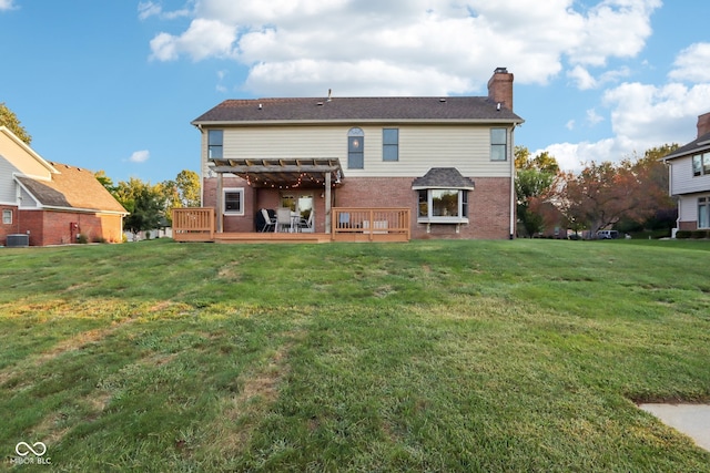 rear view of property with a lawn, a deck, and a pergola