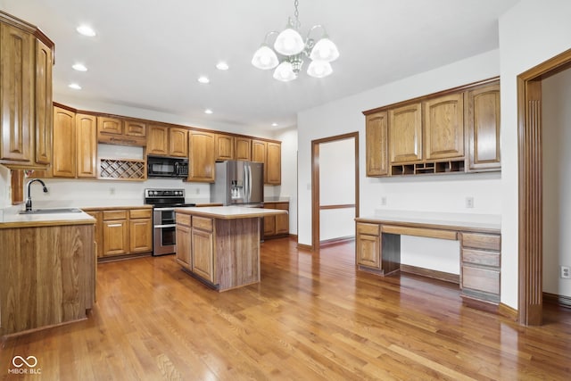 kitchen featuring sink, a center island, an inviting chandelier, wood-type flooring, and appliances with stainless steel finishes