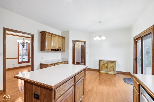 kitchen with pendant lighting, a center island, light wood-type flooring, and a chandelier