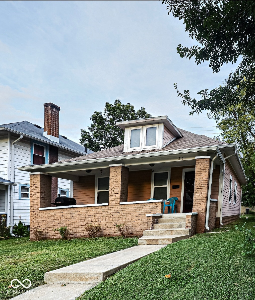 view of front of home featuring a front yard and a porch