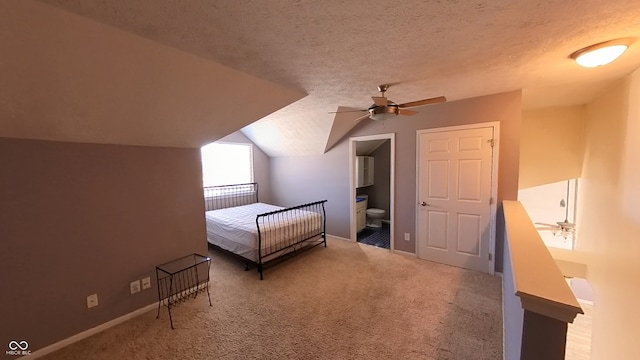 unfurnished bedroom featuring ensuite bathroom, ceiling fan, a textured ceiling, carpet floors, and vaulted ceiling