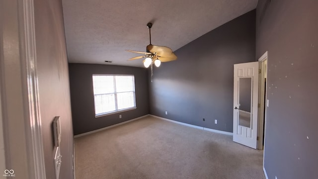 spare room with ceiling fan, a textured ceiling, lofted ceiling, and light colored carpet