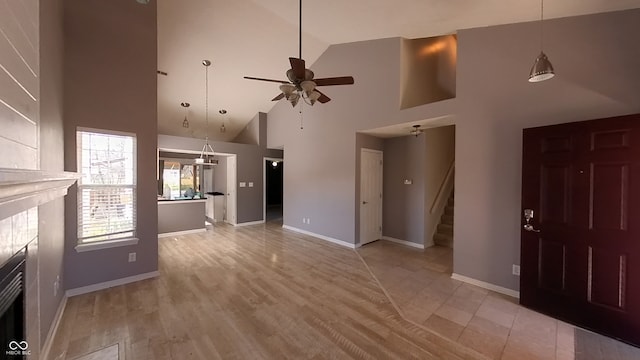 unfurnished living room featuring high vaulted ceiling, light hardwood / wood-style floors, and ceiling fan