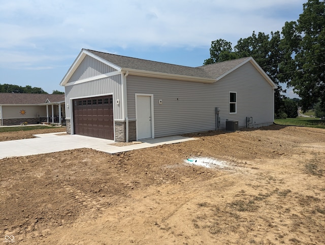 view of property exterior featuring a garage and central AC unit