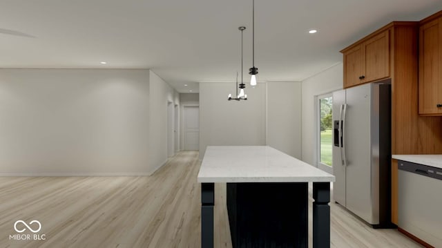 kitchen featuring decorative light fixtures, appliances with stainless steel finishes, a center island, and light hardwood / wood-style flooring