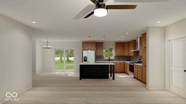 kitchen featuring a healthy amount of sunlight, white appliances, hanging light fixtures, and a kitchen island