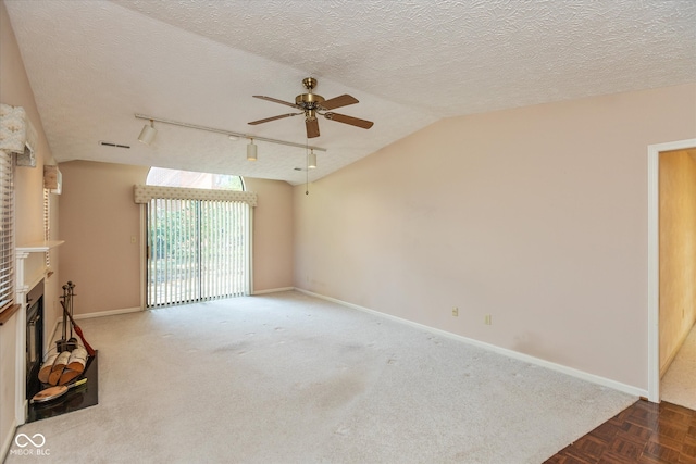 unfurnished living room with parquet flooring, track lighting, a textured ceiling, a brick fireplace, and ceiling fan