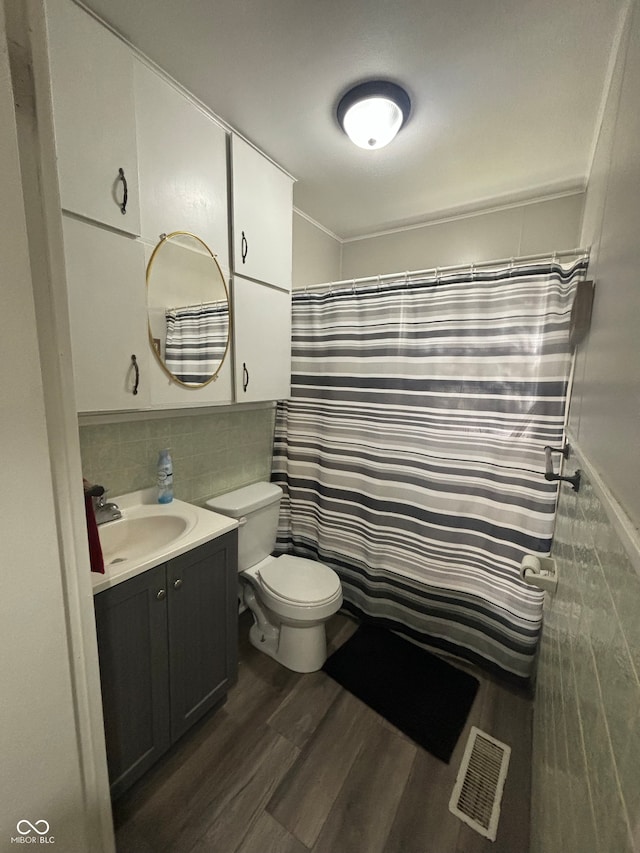 bathroom with a shower with shower curtain, hardwood / wood-style flooring, vanity, and toilet