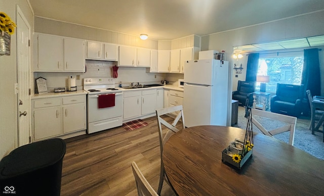 kitchen featuring white cabinetry, white appliances, dark hardwood / wood-style flooring, ceiling fan, and sink