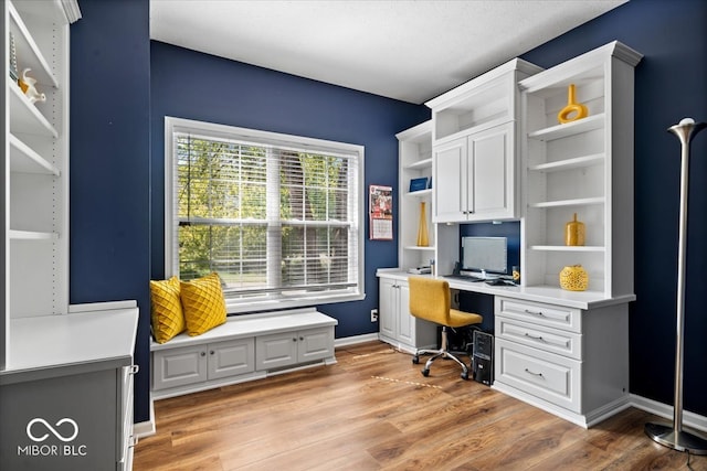 office space with light hardwood / wood-style flooring and built in desk