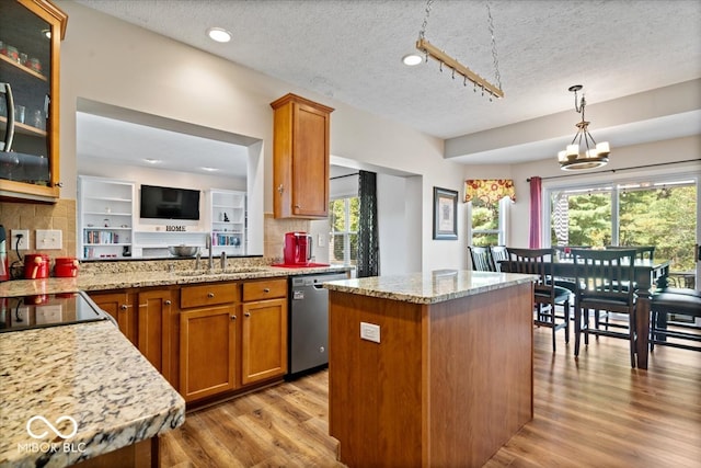 kitchen with a kitchen island, a textured ceiling, dishwasher, an inviting chandelier, and light hardwood / wood-style floors