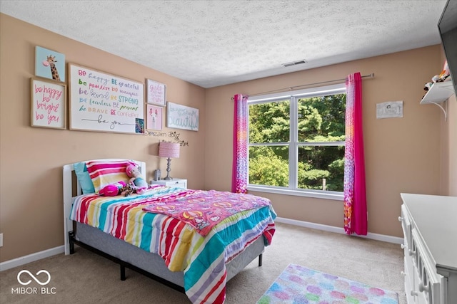 bedroom featuring light colored carpet and a textured ceiling