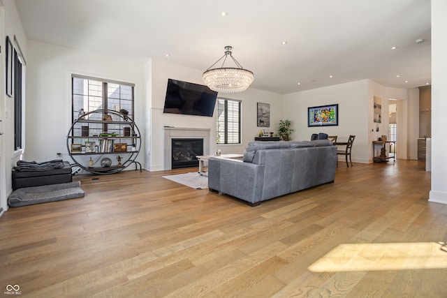 living room with light hardwood / wood-style floors and an inviting chandelier