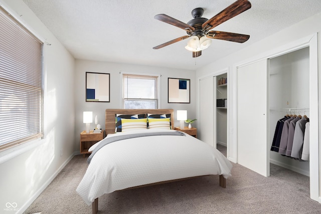 carpeted bedroom with ceiling fan and a textured ceiling