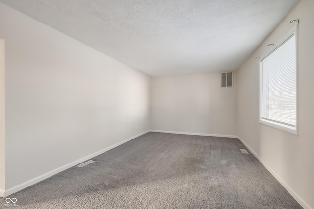 carpeted empty room with a textured ceiling