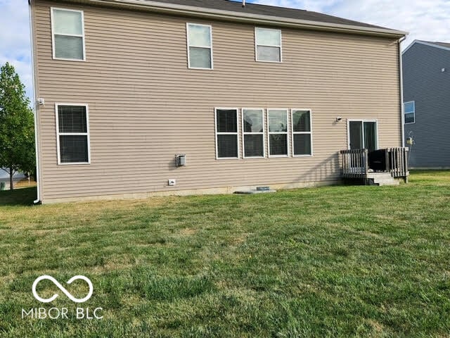 back of house featuring a lawn