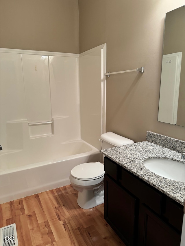 full bathroom featuring tub / shower combination, hardwood / wood-style floors, vanity, and toilet