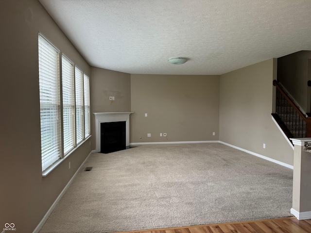 unfurnished living room featuring wood-type flooring and a textured ceiling