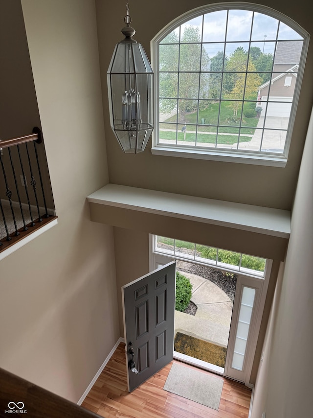 foyer with light hardwood / wood-style floors and a notable chandelier