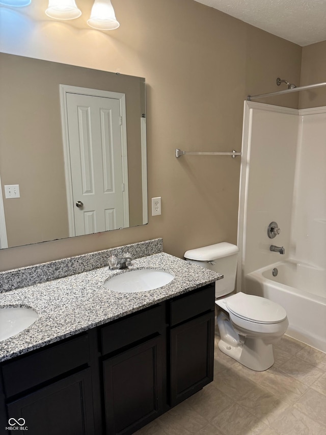 full bathroom with washtub / shower combination, a textured ceiling, vanity, and toilet